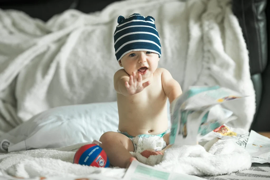 Un enfant qui tend les mains et une couche
