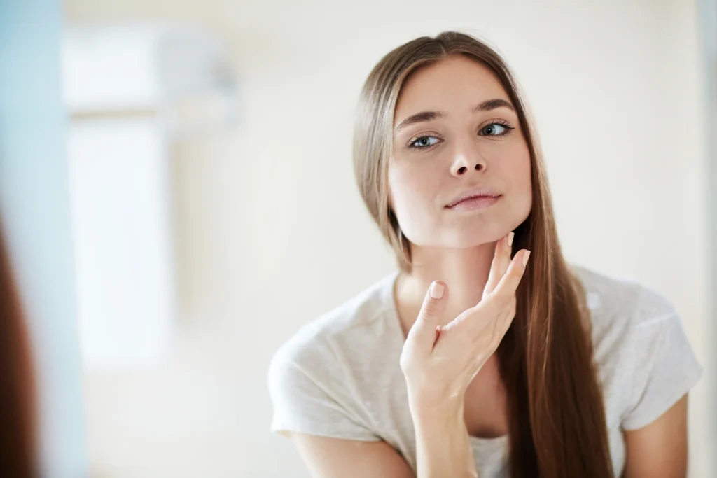 Une femme qui se touche le visage en se regardant
