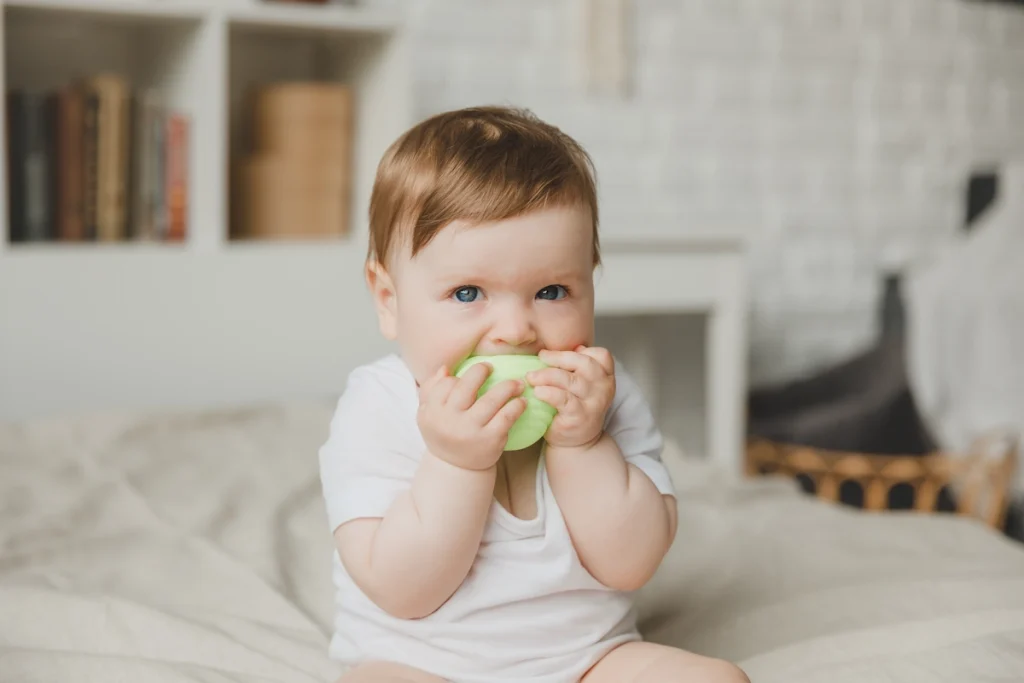Un petit garçon de 18 mois assis en mangeant quelque chose