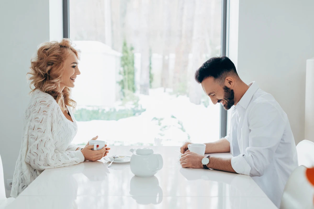 Un homme et une femme qui rigole autour d'une tasse de café
