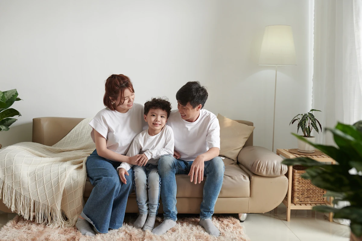 Une famille assise sur un canapé avec le sourire