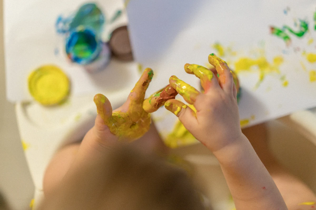 Un enfant avec les doigts peintes de peinture