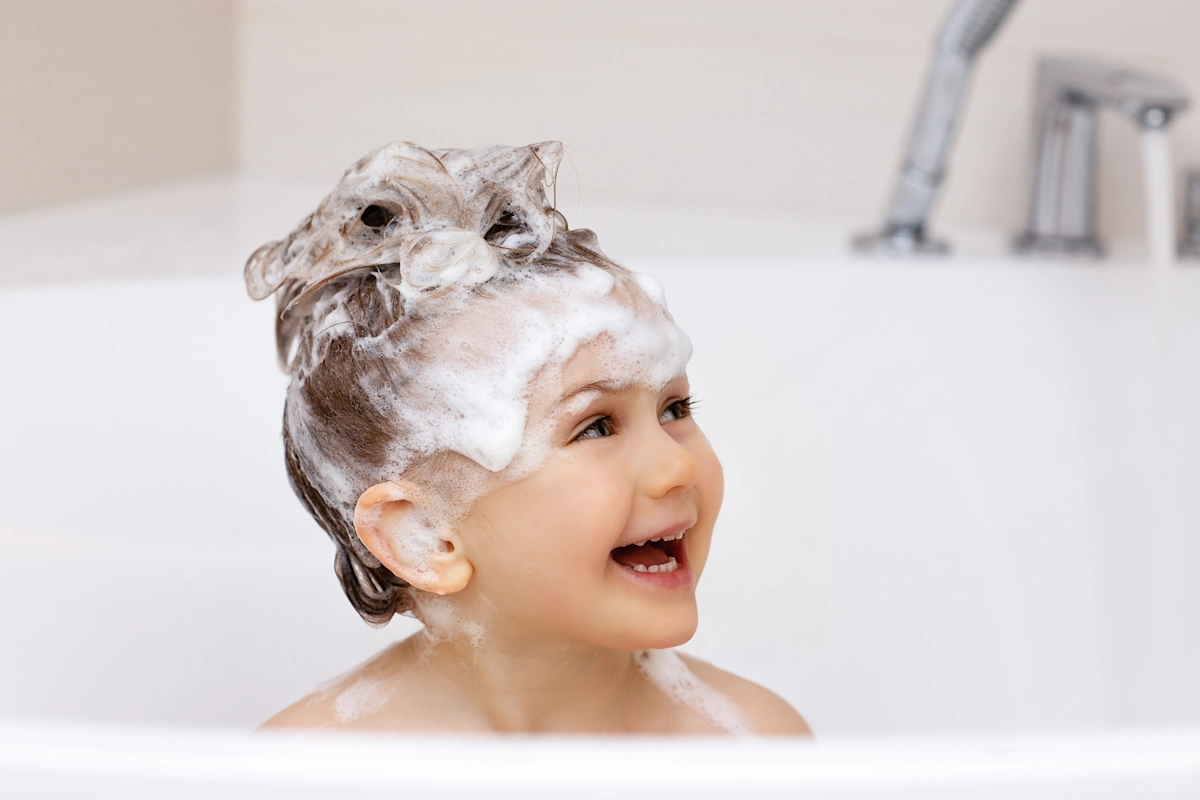 Un enfant avec les cheveux plein de shampoing