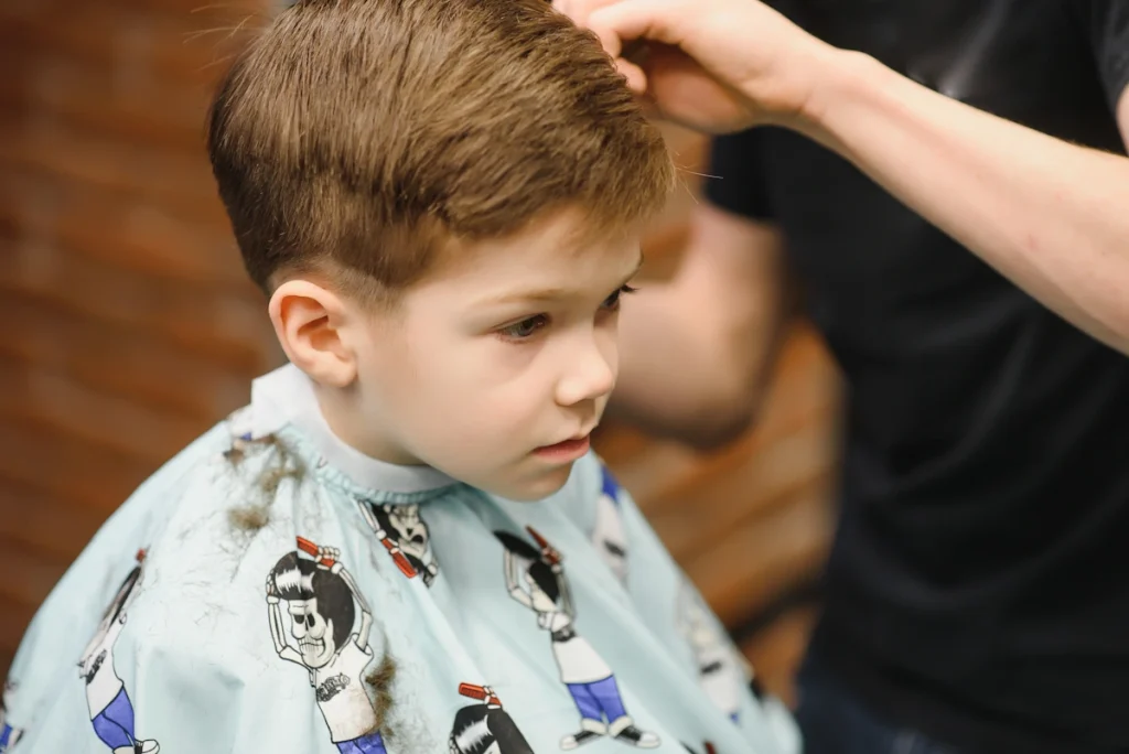 Un petit garçon qui se laisse toucher les cheveux