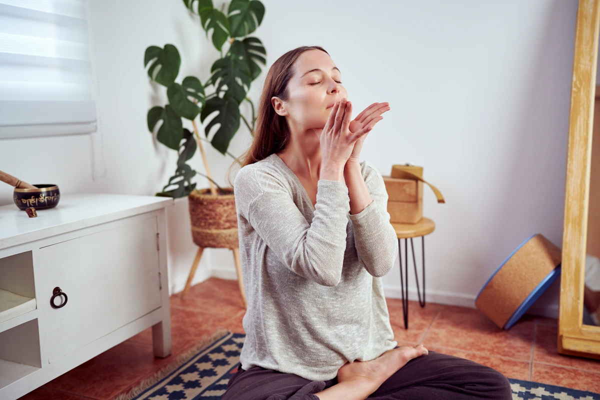 Une femme en position lotus qui masse son menton