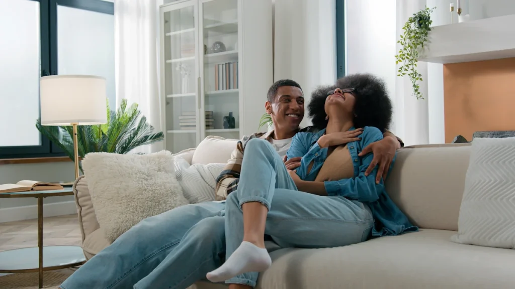 Un couple qui discute en riant sur un canapé