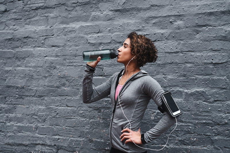 femme qui s'hydrate pendant une séance de running