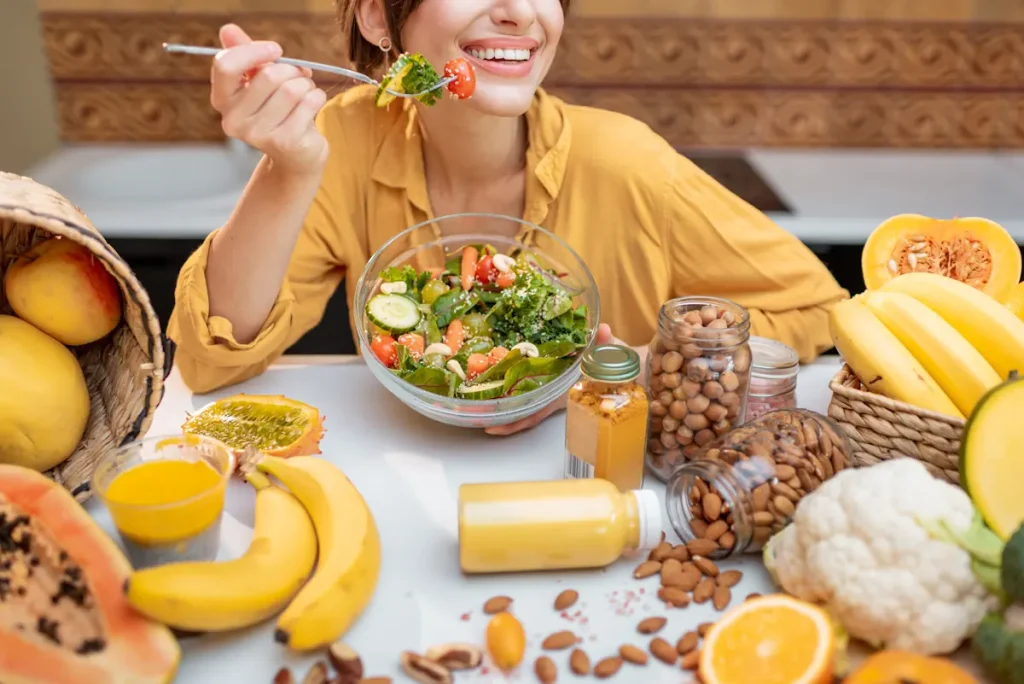 Une femme qui mange avec le sourire et qui est de plusieurs aliments jaunes