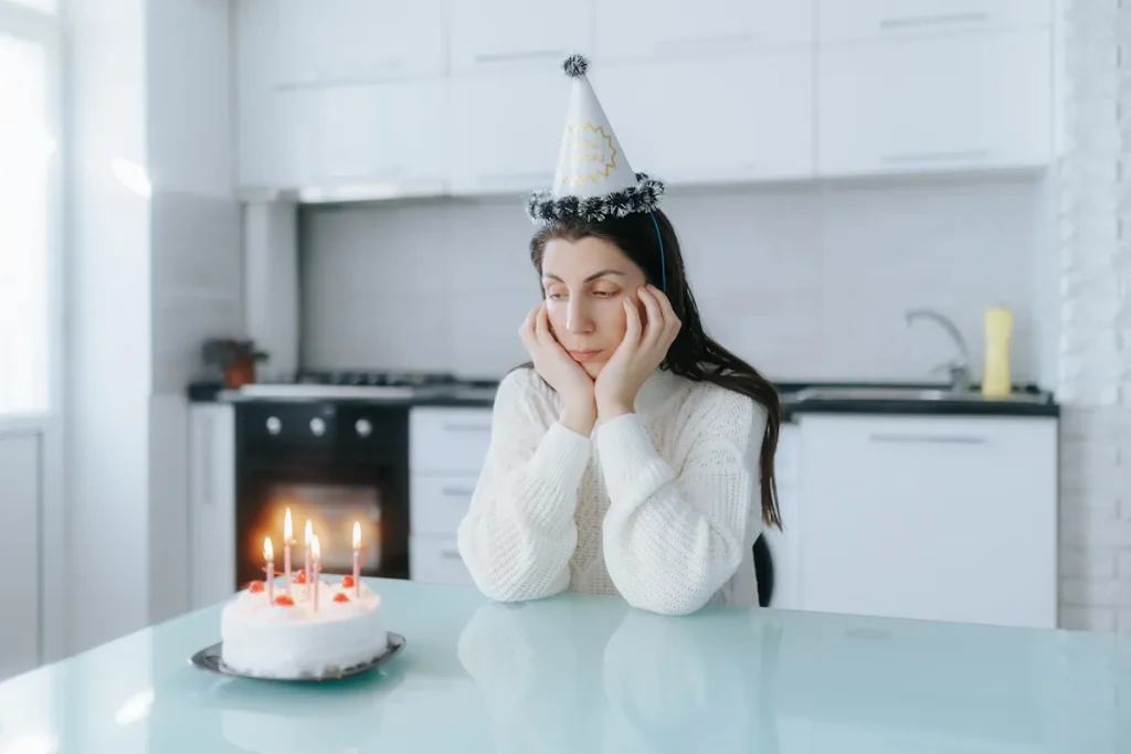 Une femme qui fête son anniversaire avec un gâteau mais sans cadeau