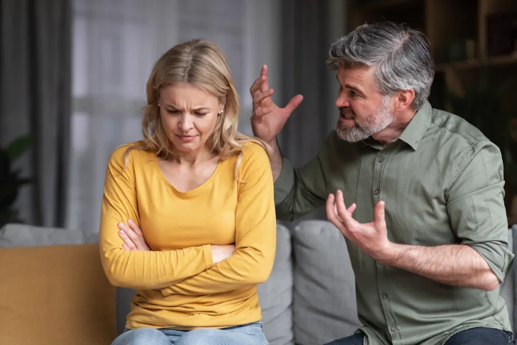 Un homme avec les cheveux gris et blanc qui cris sur une femme