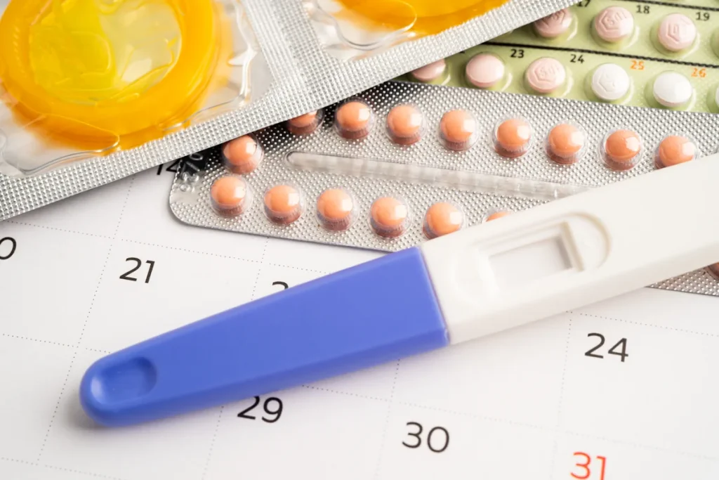 Un test de grossesse posé à côté de pilules