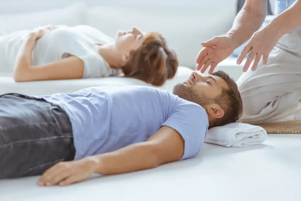 un homme qui dort sur le sol à côté d'une femme et qui se laisse guider par un homme
