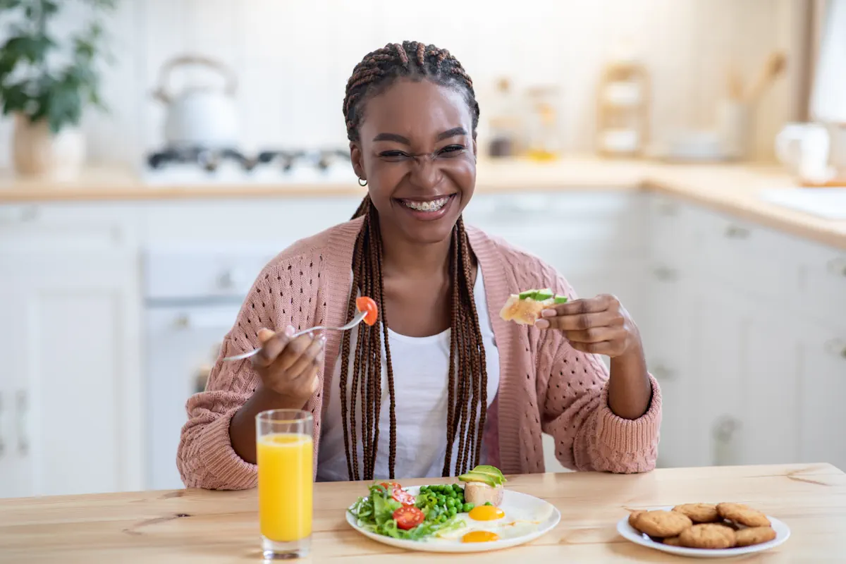 Une jeune femme qui mange avec le sourire