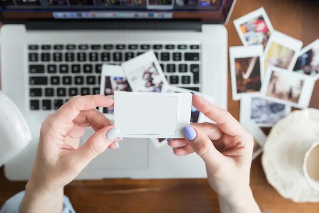 Une personne qui regarde des photos à côté de son ordinateur