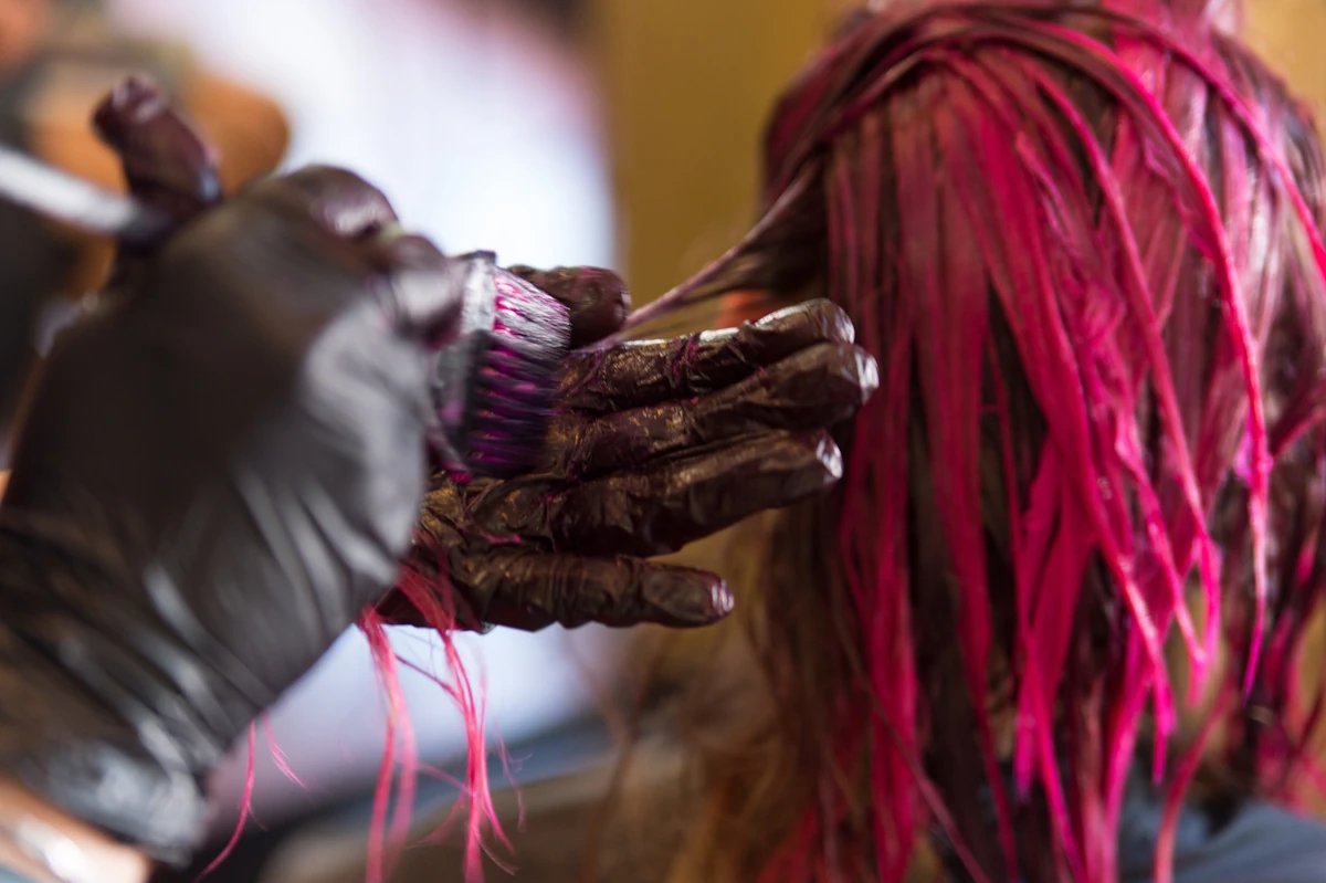 Une femme qui se fait traiter les cheveux violets