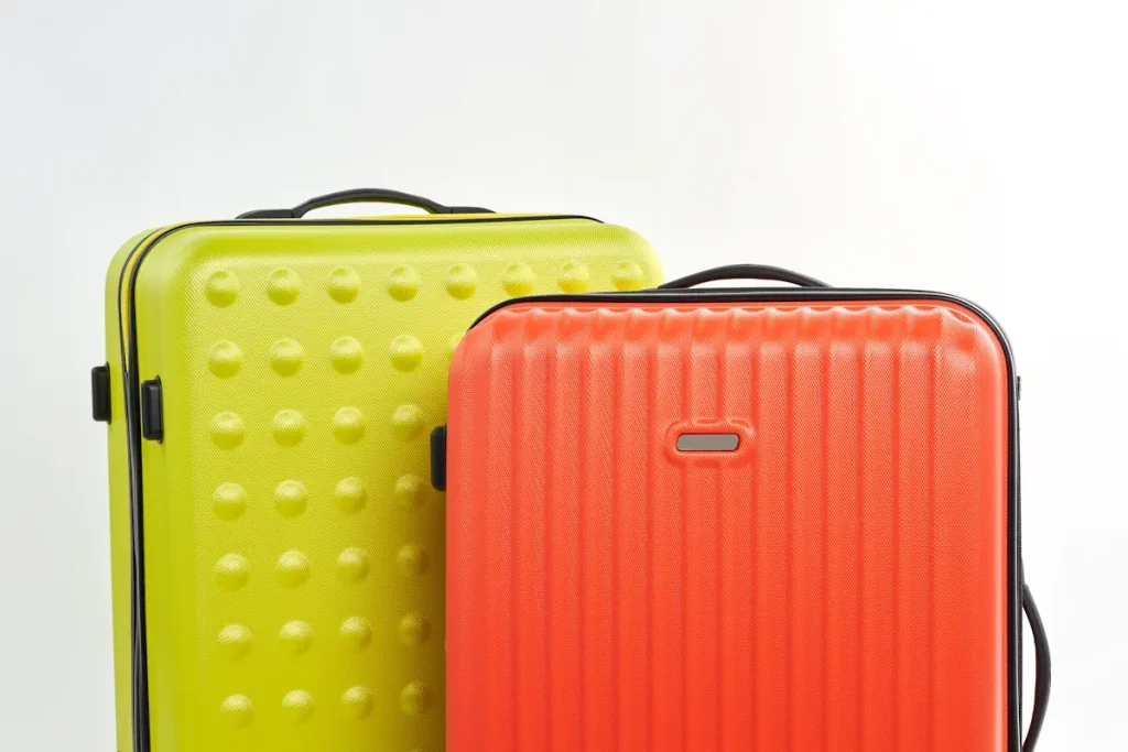Deux valises l'une à côté de l'autre. Une jaune et une autre orange