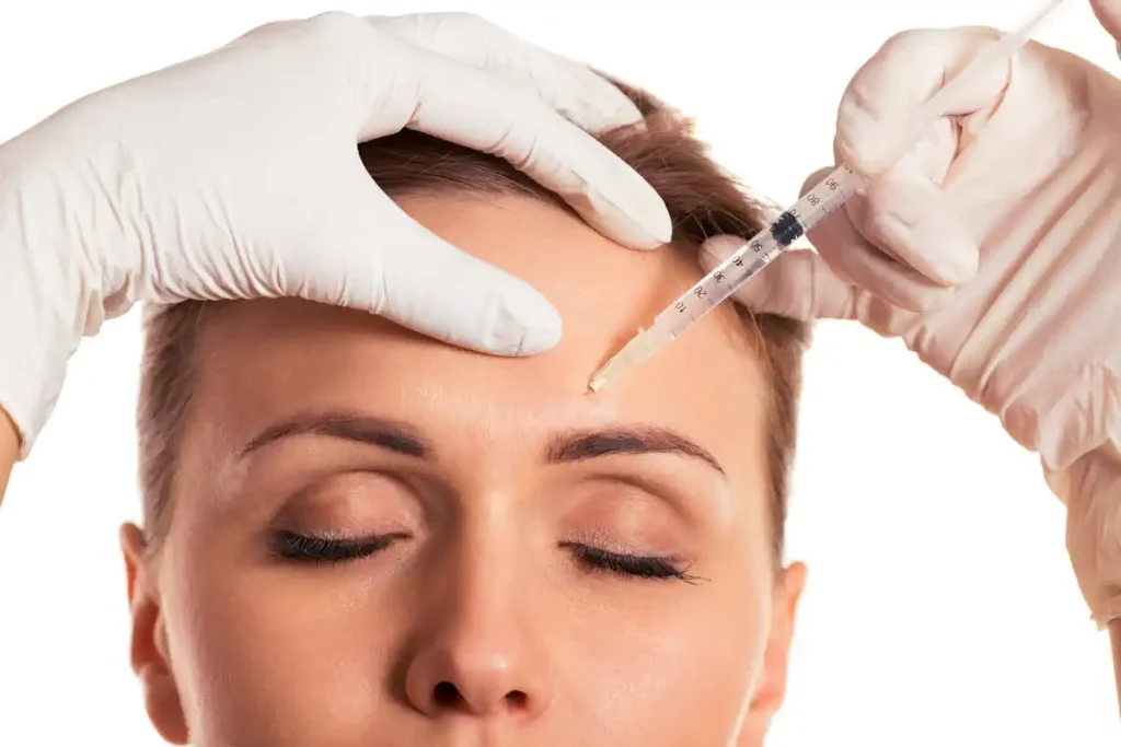 Une femme qui subit une injection de botox sur le front