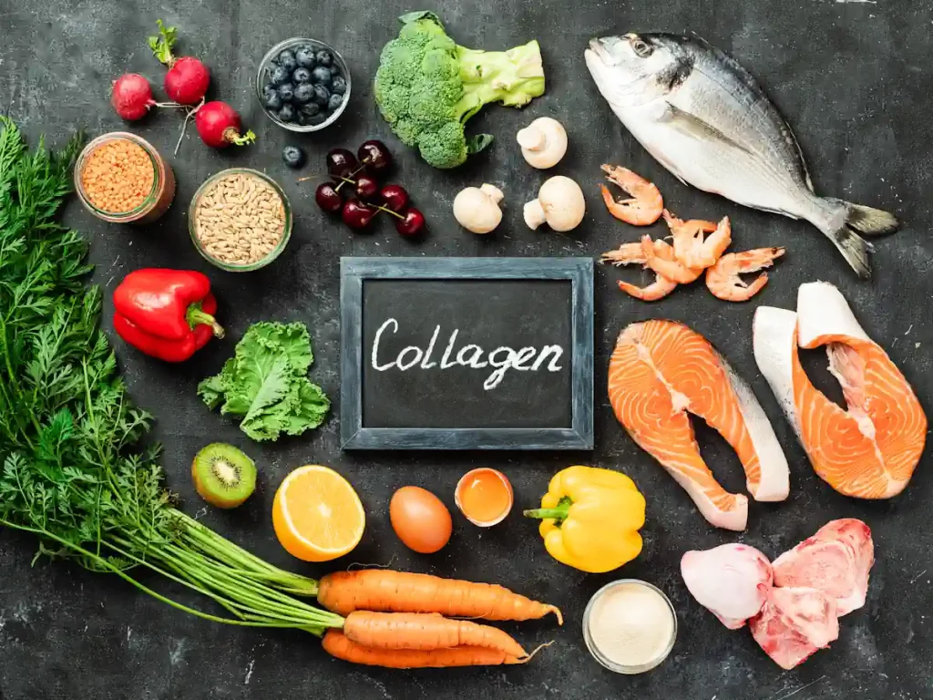 Différents aliments posés sur une surface noir avec au milieu une ardoise où est écrit Collagen
