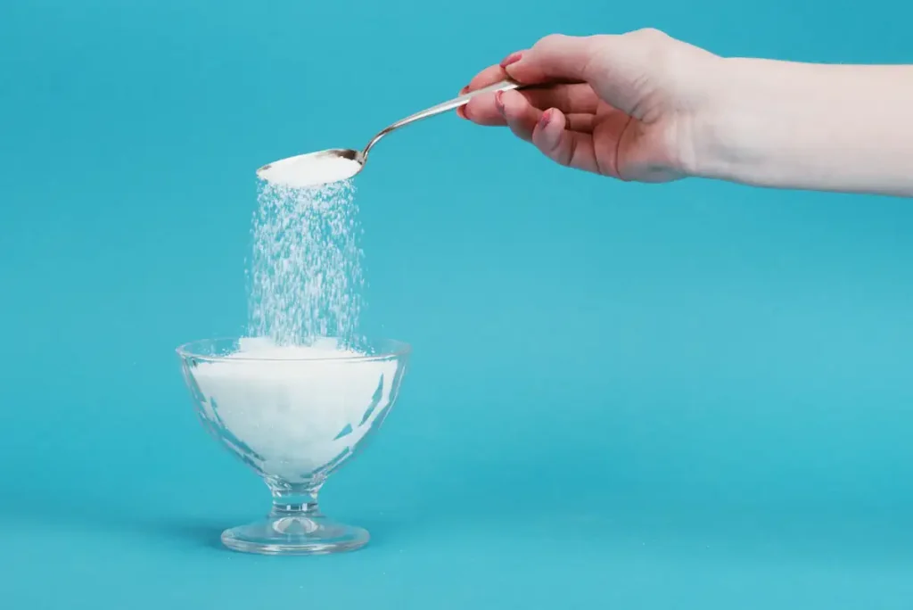 Une personne qui joue avec du sucre avec une cuillère