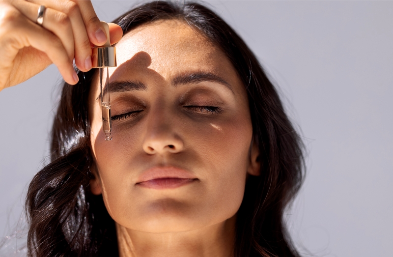 femme qui met du sérum sur le visage