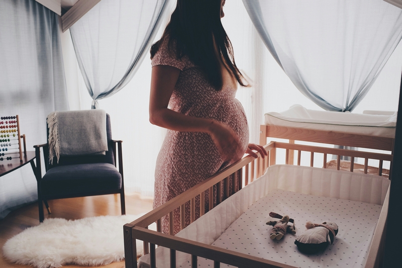 femme enceinte qui regarde le berceau