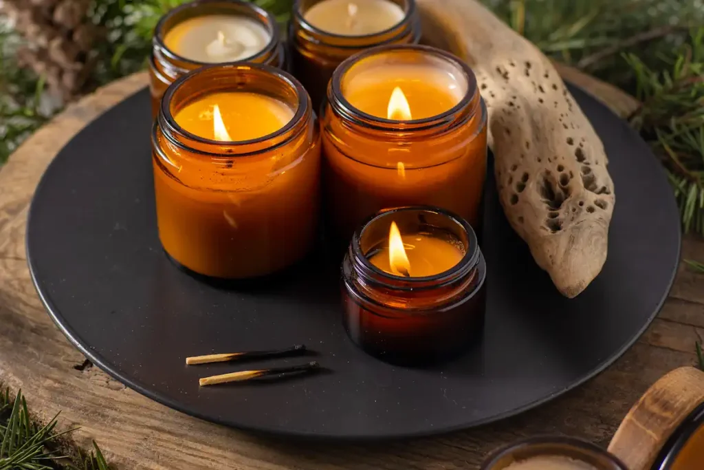 3 bougies dans des bocaux marrons allumées