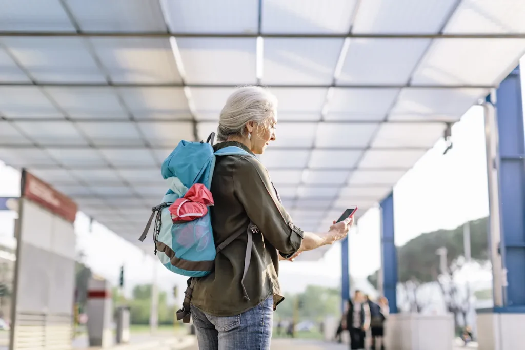 Une femme avec un sac à dos qui regarde son smartphone
