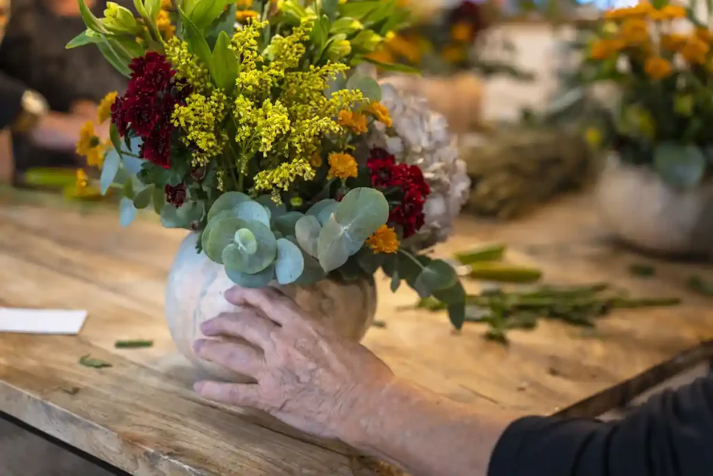 Une personne qui fait une composition de fleurs naturels