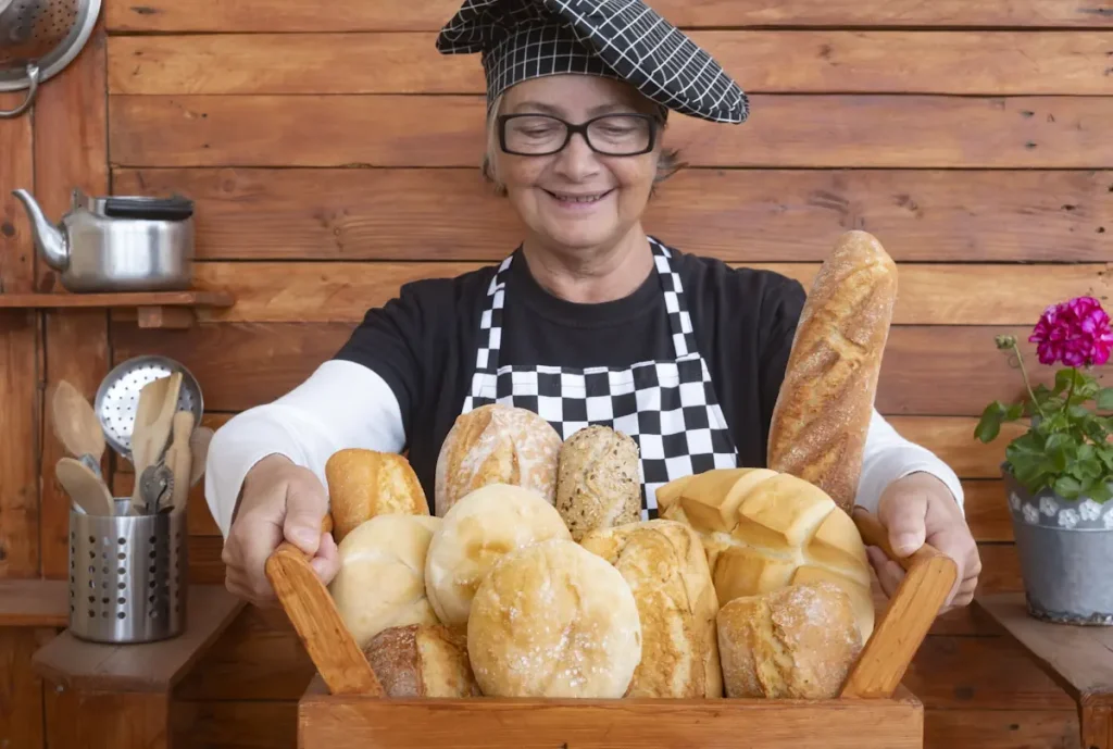 Une femme avec une toque noir qui porte un panier avec plusieurs pains à l'intérieur