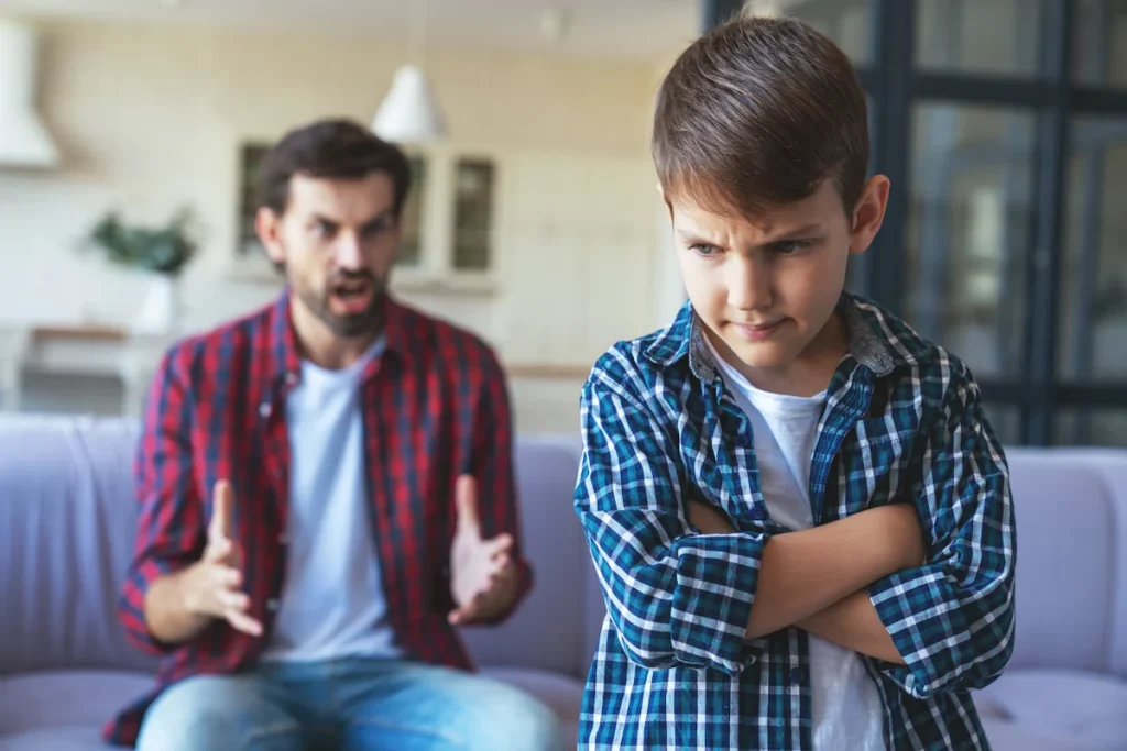 Un homme qui crie sur un petit garçon