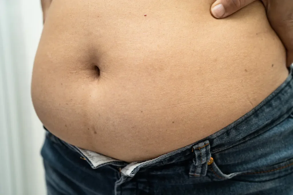 Le ventre d'une femme en jean qui est gonflé