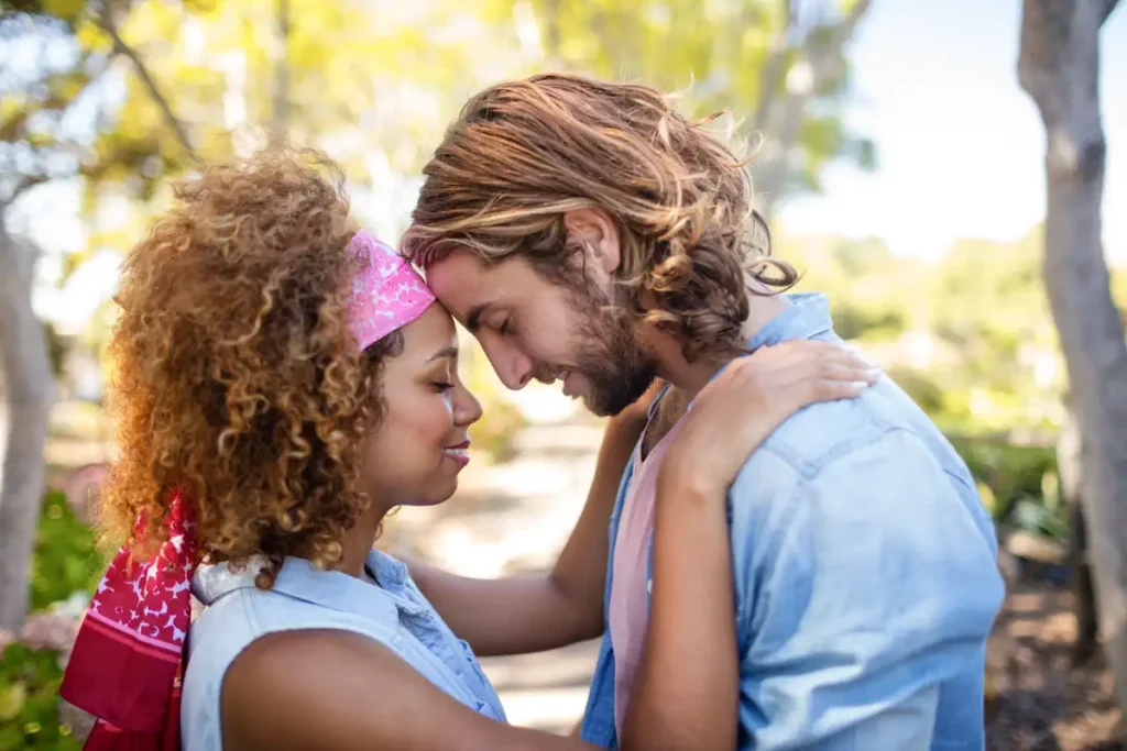 Un homme et une femme qi se tiennent dans les bras en fermant les yeux