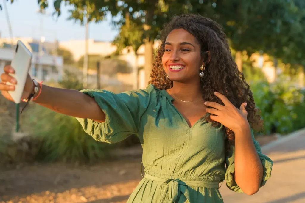 Une femme qui sourit en se prenant en phoro