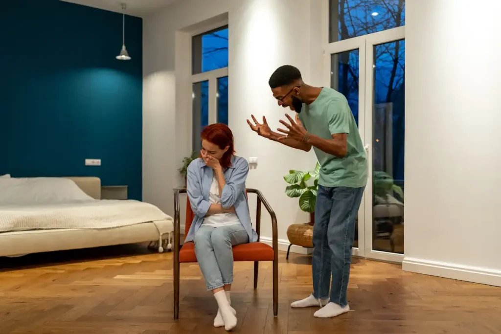 Une femme assise sur une chaise avec un homme qui crit après elle