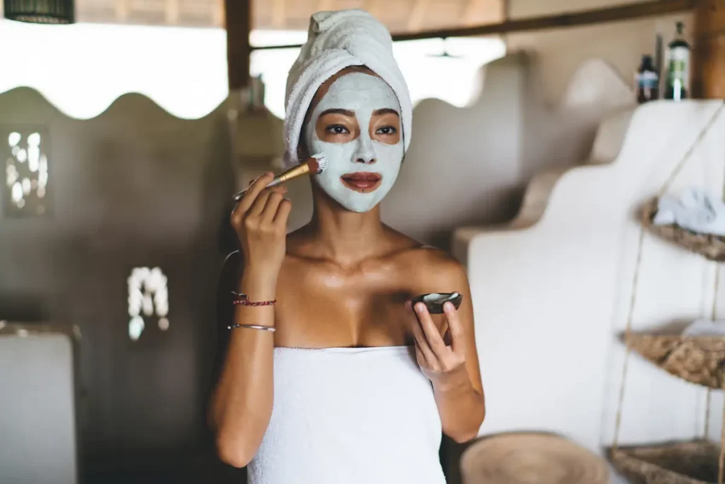 Une femme qui applique un masque sur son visage