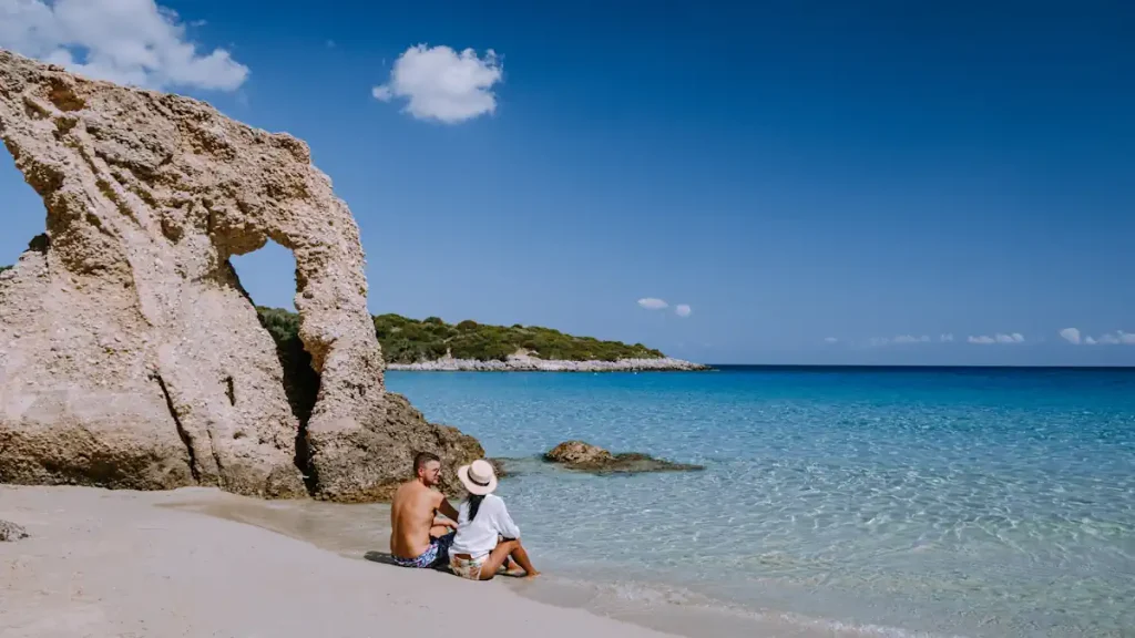 Un couple posé sur la plage face à la mer