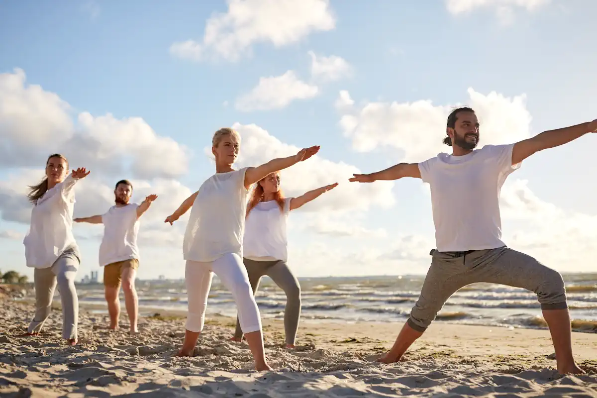 Un groupe de personne qui font du yoga sur la plage