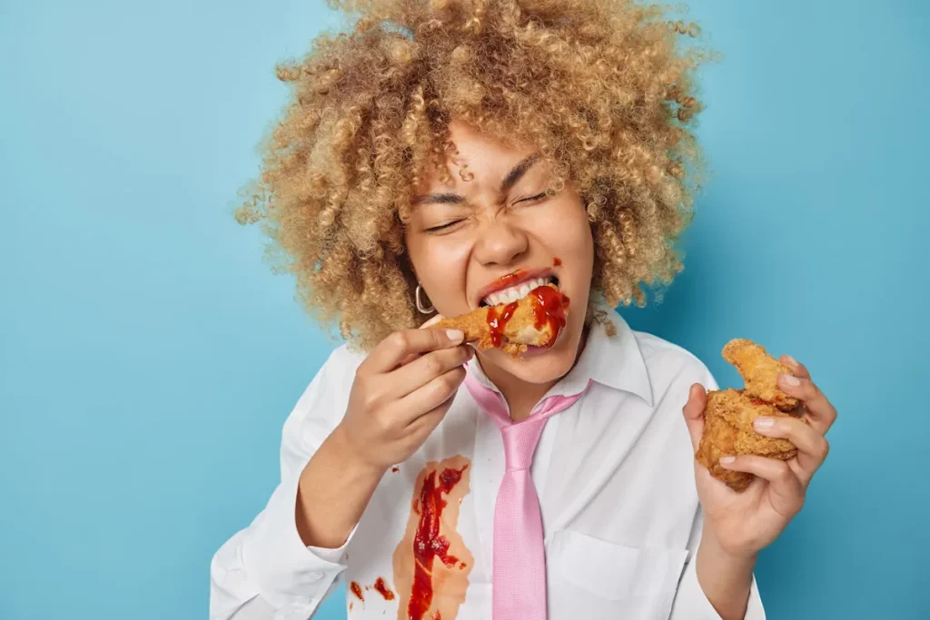Une femme qui mange quelque chose en se tachant