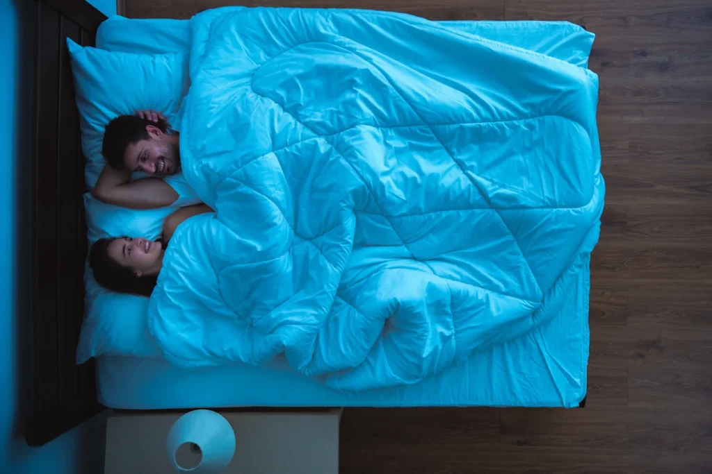Un couple dans un lit sur le point de se coucher