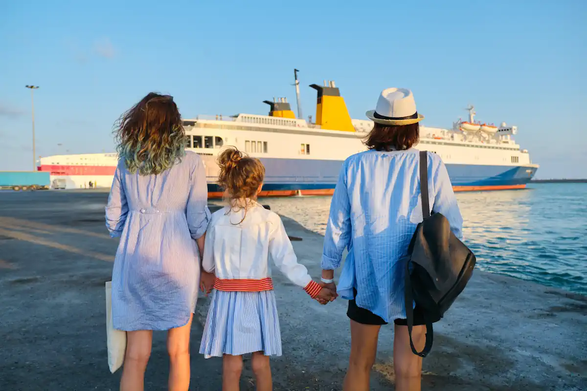 Une femme avec deux enfant face à un ferry