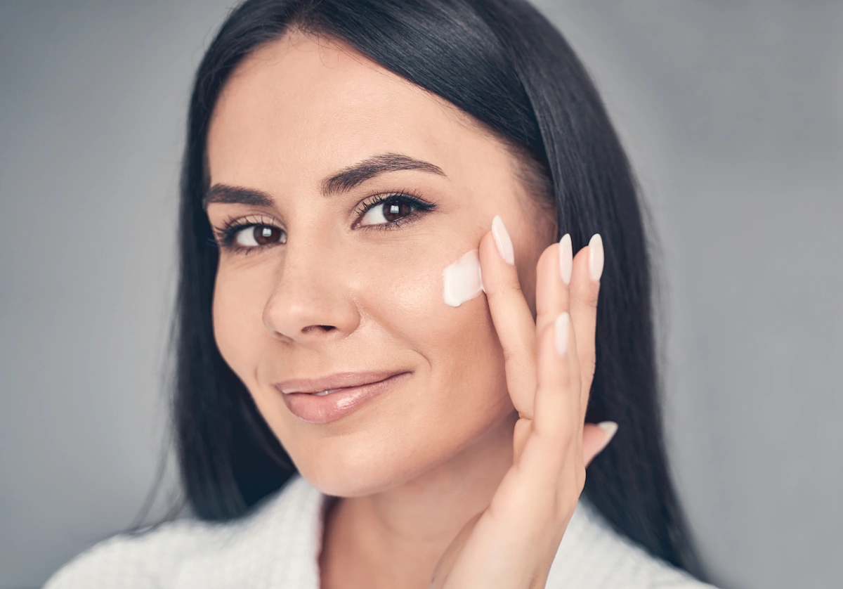 Une femme qui applique un produit sur le visage