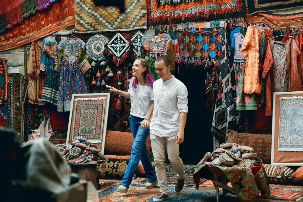 Un homme et une femme au milieu d'un marché avec plusieurs produits artisanaux