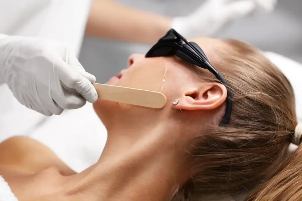 Une femme qui se laisse appliquer un produit sur le visage