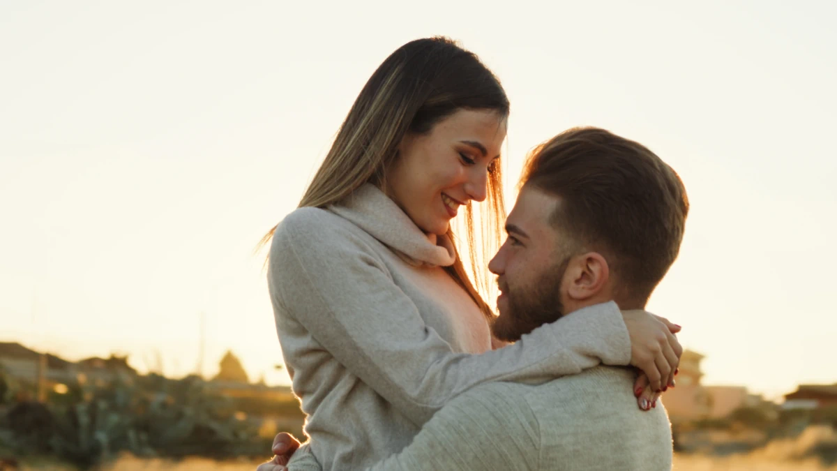 Une femme dans les bras d'un homme qui le regarde avec tendresse