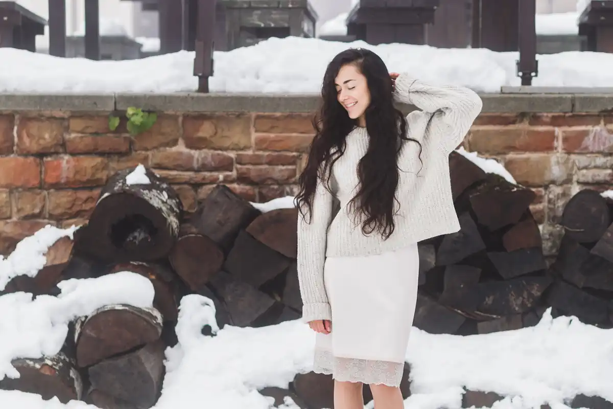 Une femme qui porte un pull et une robe blanche