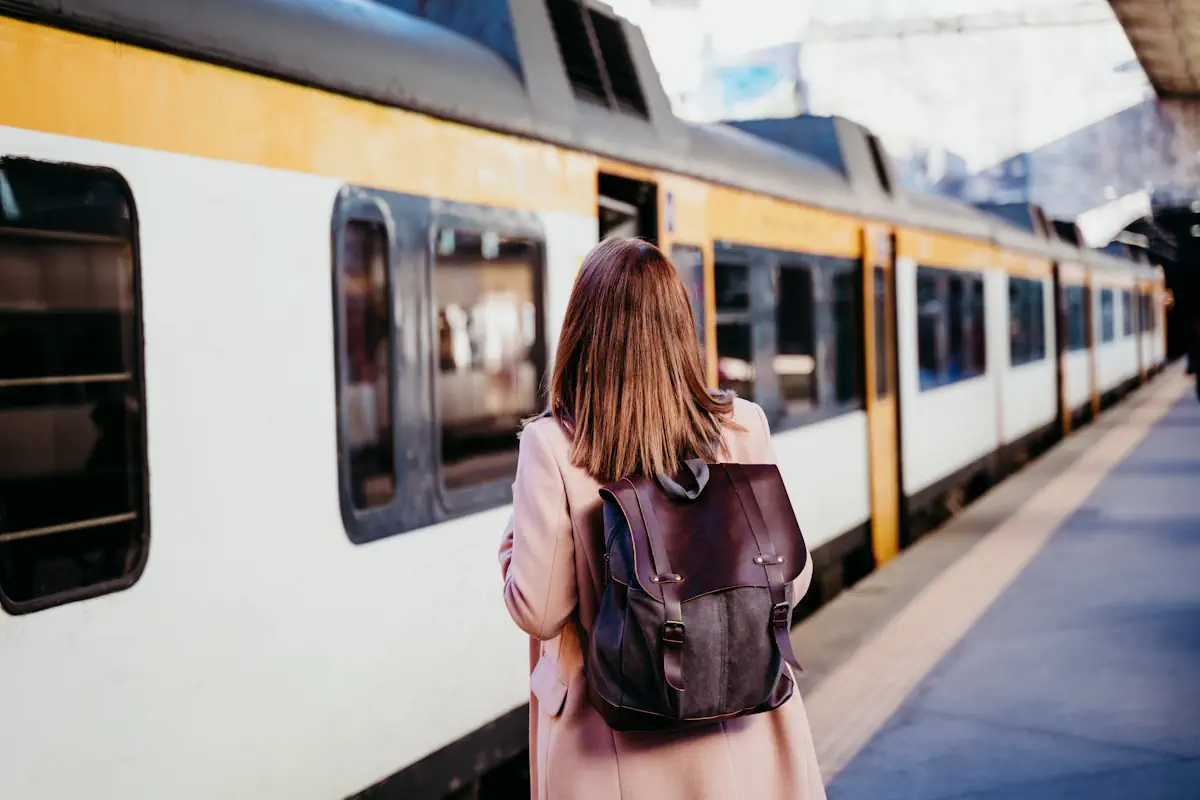 Une femme qui attend sur le quais d'une gare en face d'un train