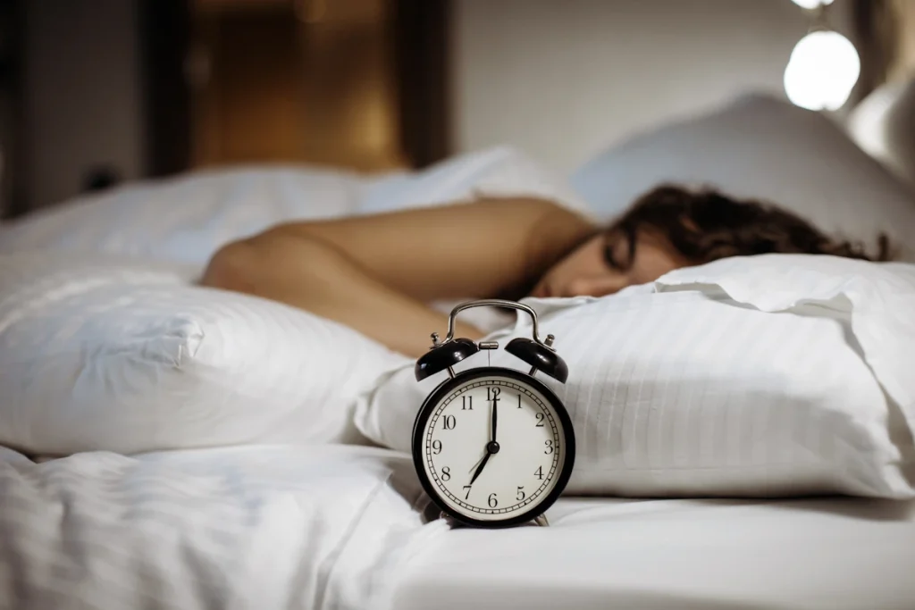 Une femme qui dort à côté d'un réveil