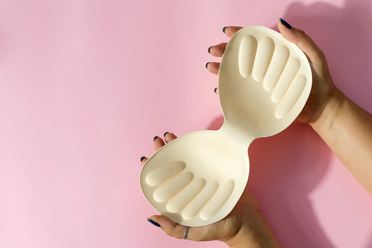 Une personne qui tient un soutien gorge adhésif beige