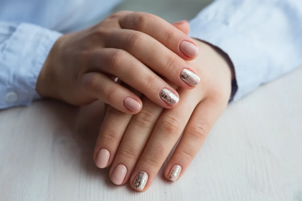 Des mains d'une femme posée en croisée avec des vernis chromes