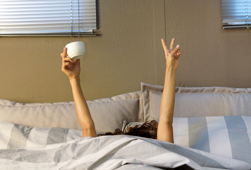femme dans son lit avec son café
